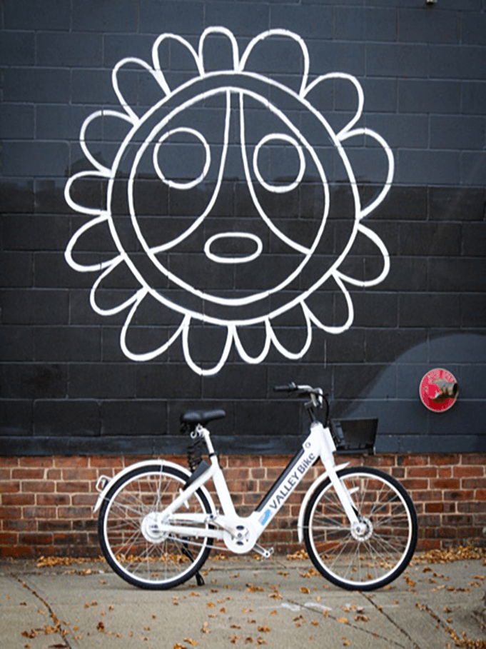 White Butterfly bike parked in front of a mural