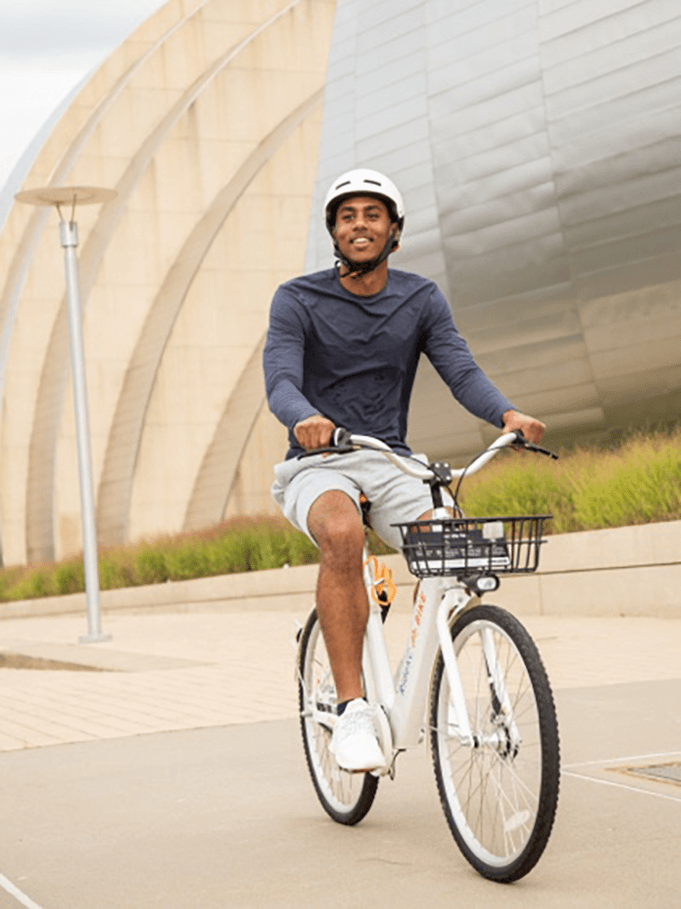 Rider on a white Butterfly bike near a modern building